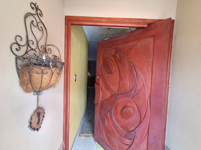 Entrance area featuring a decorative solid wood carved front door and tiled flooring, leading into the main living space.