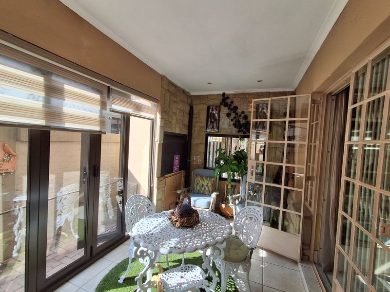 Enclosed patio area featuring stone cladding, tiled flooring, and large sliding glass doors providing access to the outdoor space.