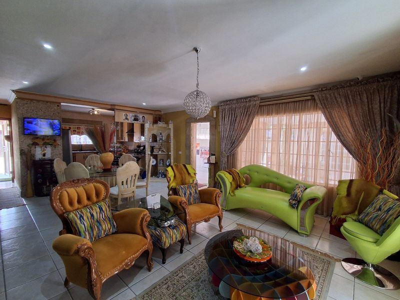 Spacious open-plan living and dining area featuring tiled floors, recessed lighting, and direct access to the outdoors through large sliding glass doors.