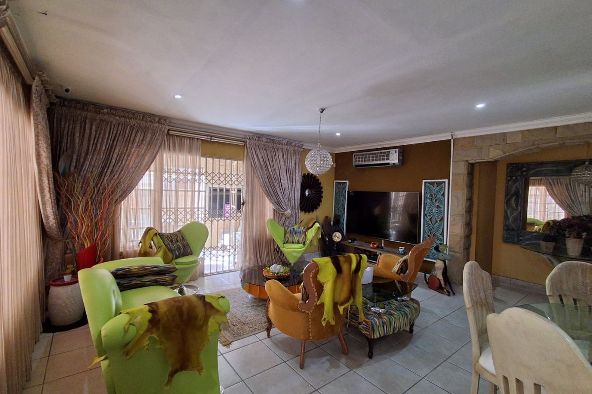 Spacious living room featuring tiled flooring, recessed lighting, a split-system air conditioner, and a decorative stone feature wall.