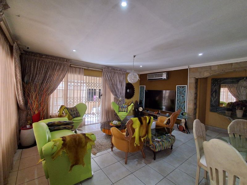 Spacious living room featuring tiled flooring, recessed lighting, a split-system air conditioner, and a decorative stone feature wall.