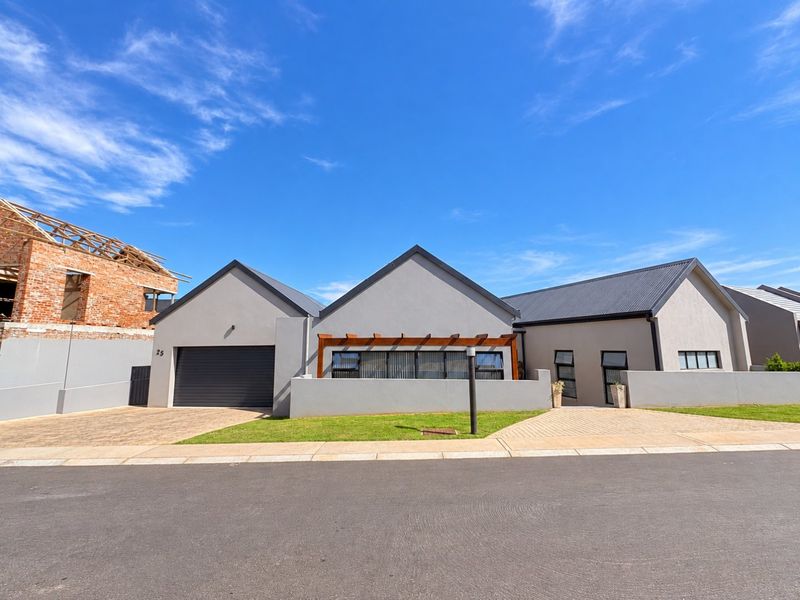 Modern single-story residential home featuring a double garage, paved driveway, and a timber pergola entrance, set within a well-maintained suburban street.