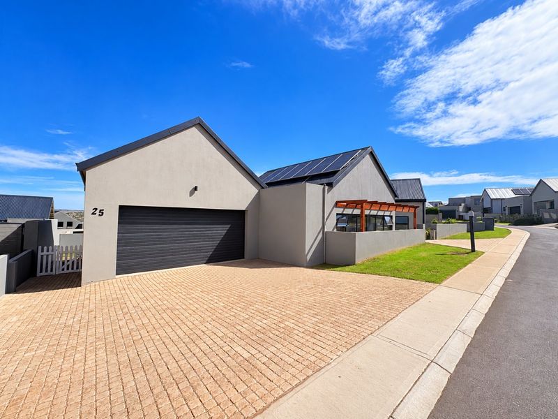 Modern single-story residence featuring a paved driveway, double garage, solar panels, and a timber pergola, situated in a well-maintained residential estate.