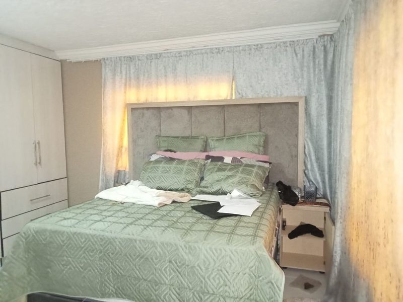 A bedroom featuring a built-in wardrobe and decorative coving, providing functional storage space within the room.