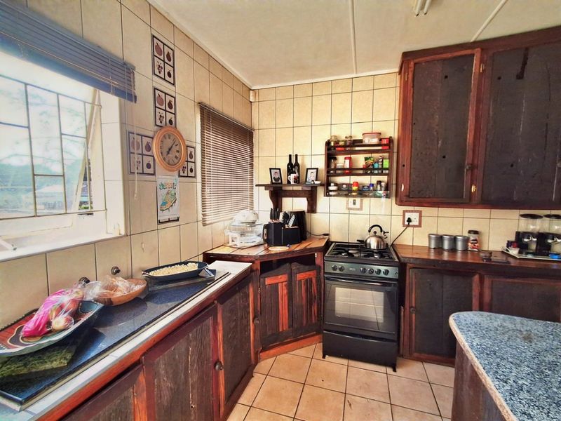 A dated kitchen featuring wooden cabinetry, tiled backsplash, and a built-in gas stove with oven, offering potential for a modern renovation.