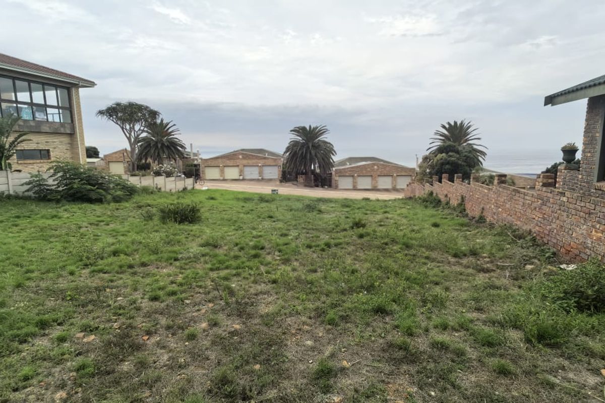 A vacant residential plot featuring established brick and concrete boundary walls, situated in a developed neighborhood with surrounding residential properties.