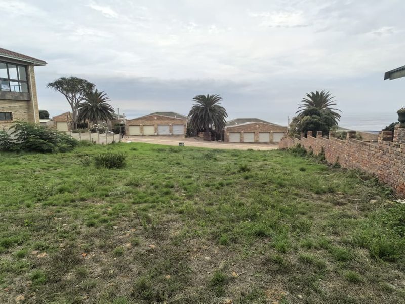 A vacant residential plot featuring established brick and concrete boundary walls, situated in a developed neighborhood with surrounding residential properties.
