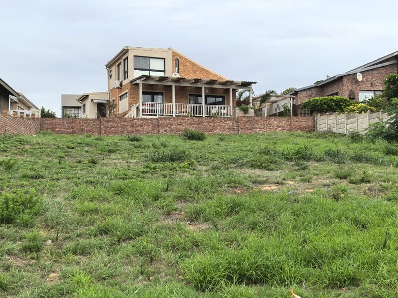 A vacant residential plot featuring a grassed surface and established brick boundary walls, situated in a developed neighbourhood.