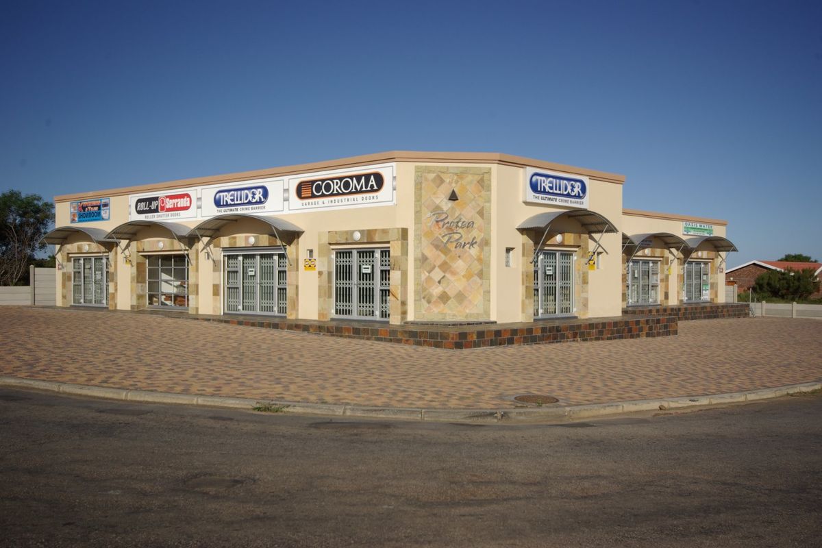 Front exterior view of Protea Park commercial building featuring paved parking, security gates, and prominent signage.