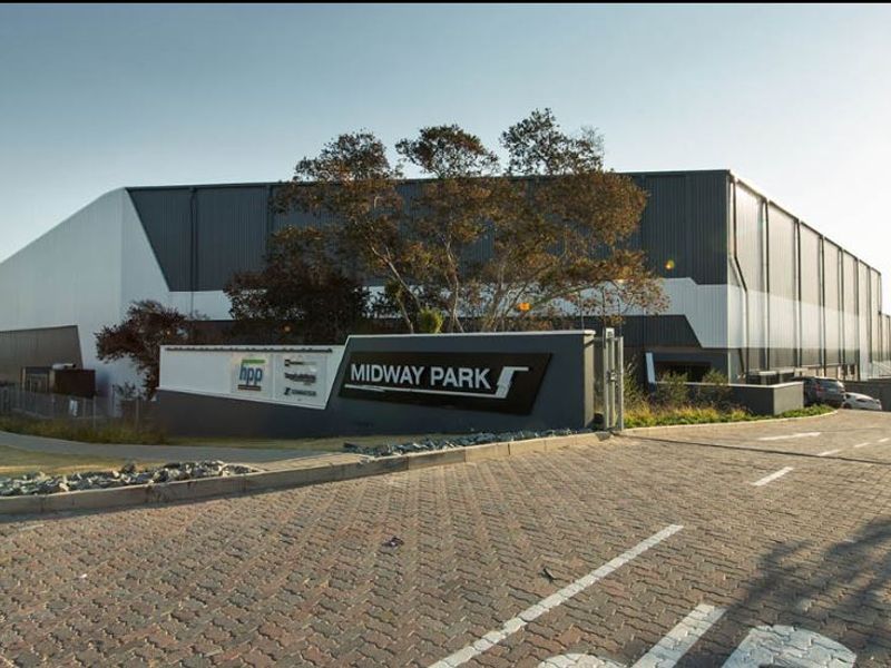 Front exterior view of Midway Park industrial facility featuring a large warehouse structure, paved access driveway, and prominent branded signage.