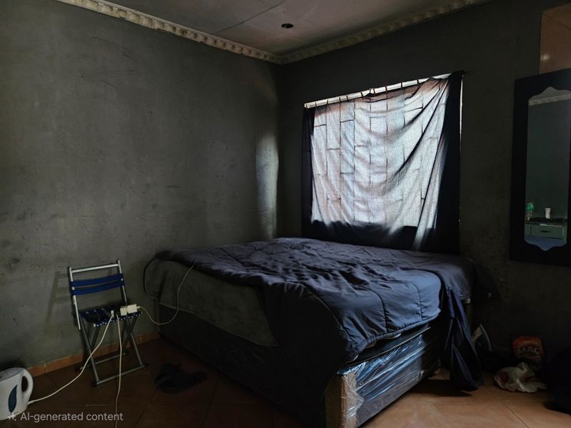 A bedroom featuring tiled flooring and decorative ceiling cornicing, currently requiring wall finishing and improved lighting to enhance the space.