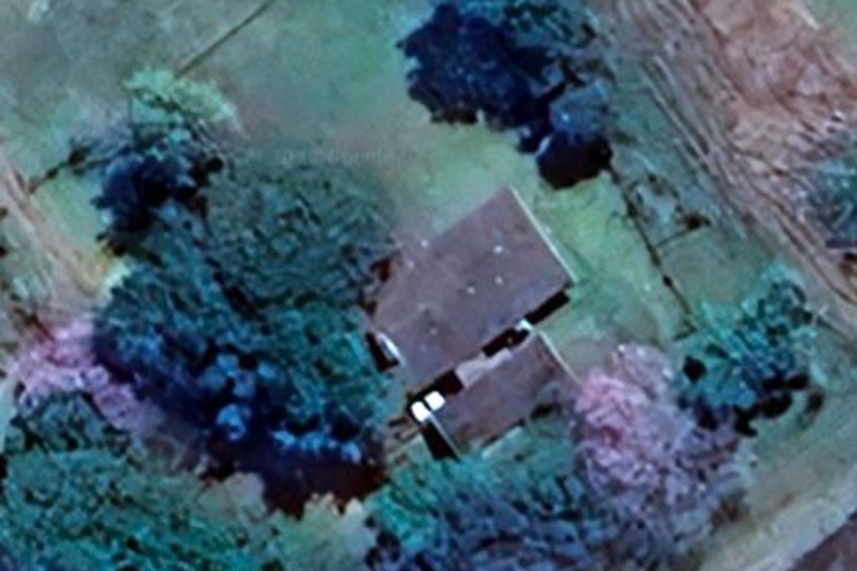 An aerial view of the property showing the roof structure and surrounding grounds.