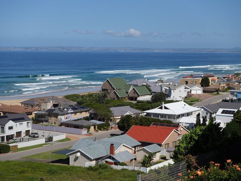 Elevated coastal view overlooking a residential neighborhood and the ocean shoreline.