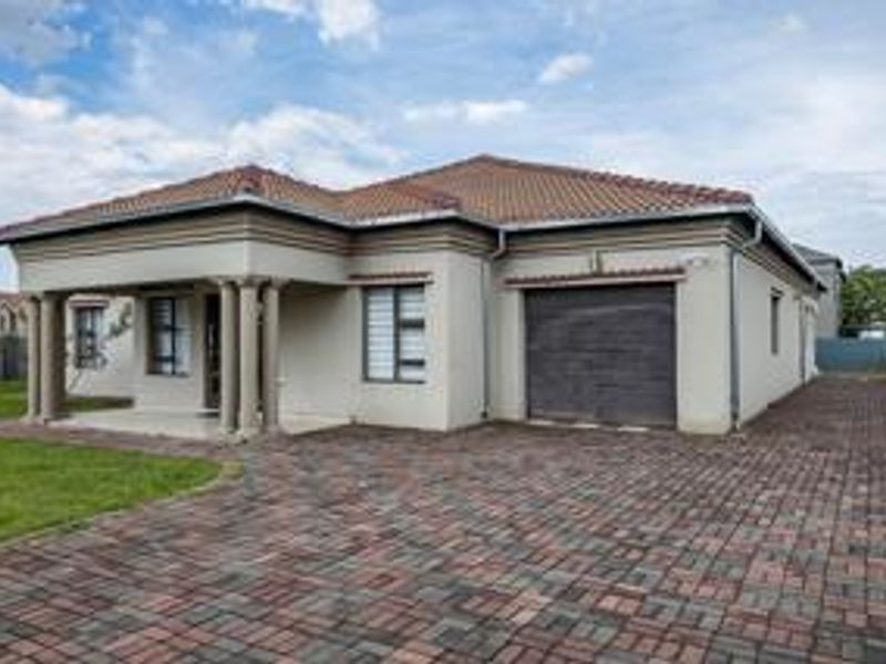A well-maintained single-story family home featuring a paved driveway, covered entrance porch with columns, and an integrated single garage.