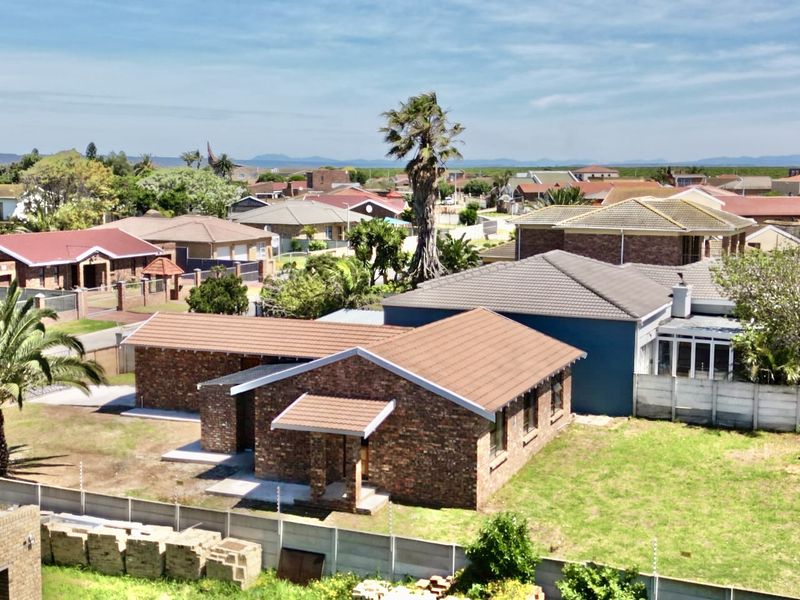 Aerial view of a facebrick house featuring a tiled roof, paved driveway, and a secure perimeter with precast walling and electric fencing.
