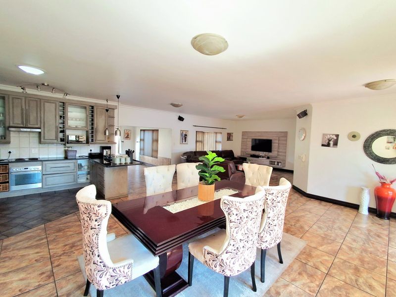 Spacious open-plan living and dining area featuring a well-equipped kitchen with built-in cabinetry and tiled flooring throughout.