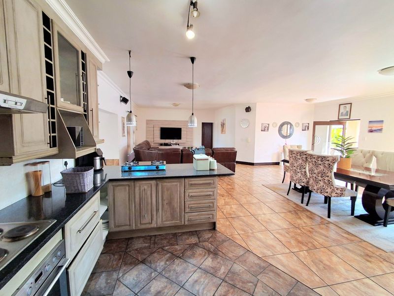 Spacious open-plan living area featuring a well-appointed kitchen with granite countertops, integrated appliances, and seamless flow to the dining and lounge spaces.