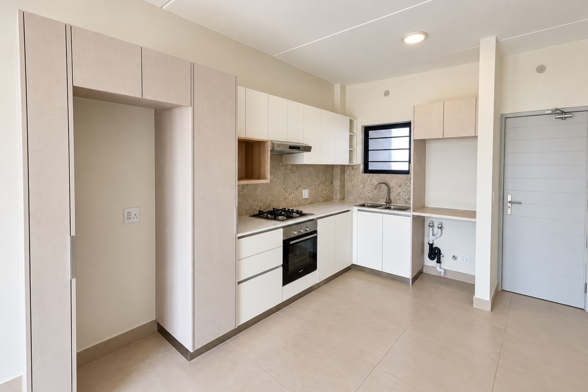 Modern, clean-lined kitchen featuring built-in cabinetry, integrated gas hob, electric oven, extractor fan, and neutral tiled flooring in an open-plan layout.