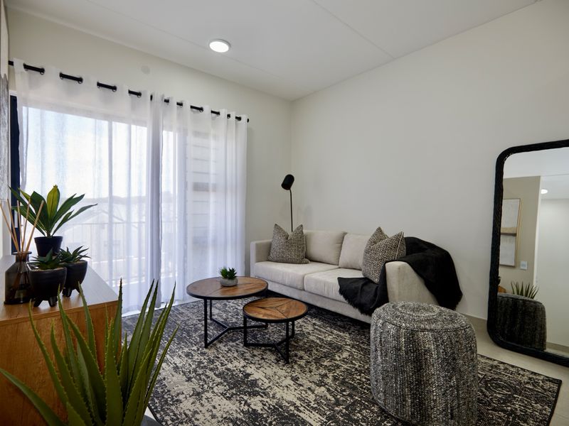 A bright and modern living room featuring a large sliding glass door that provides natural light and access to the outdoor area.