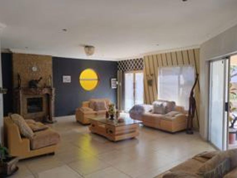 Spacious living room featuring a built-in fireplace, large format floor tiles, and sliding glass doors providing access to the outdoor area.