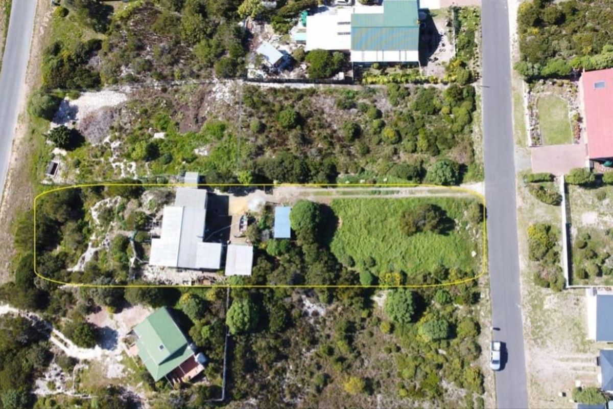 Aerial view of the farm property showing the main dwelling, surrounding grounds, and access driveway within the highlighted boundary.