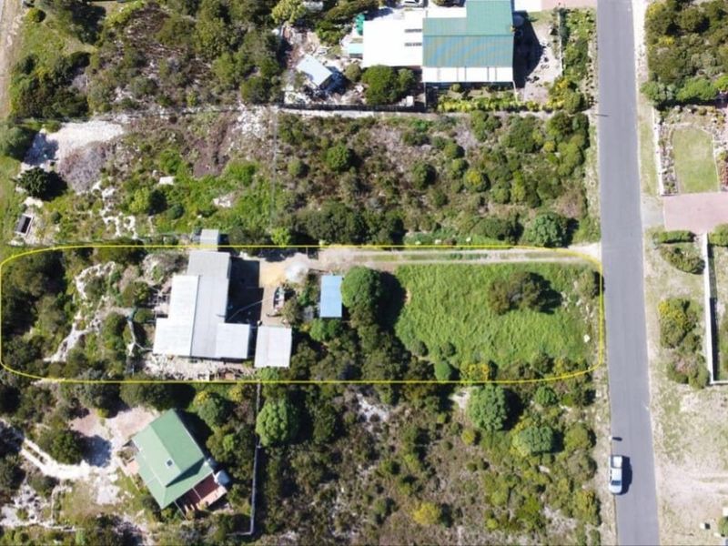 Aerial view of the farm property showing the main dwelling, surrounding grounds, and access driveway within the highlighted boundary.