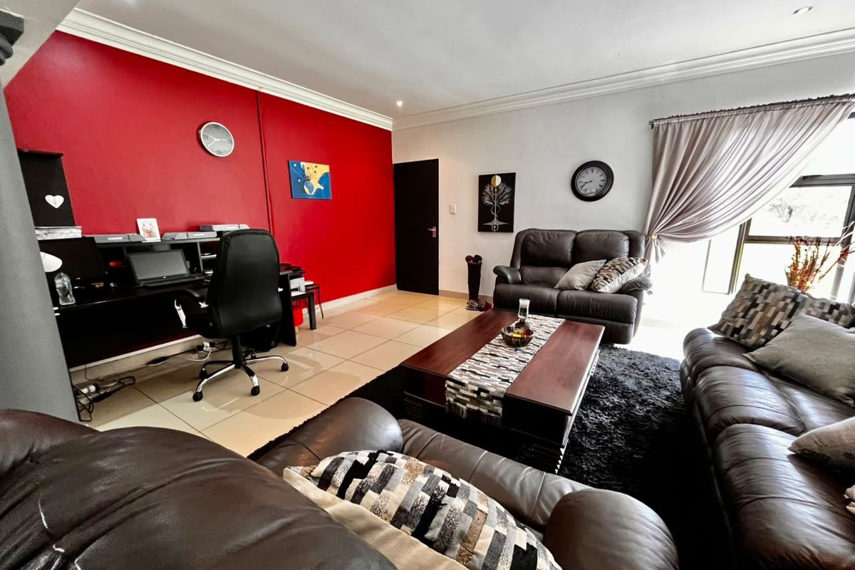 A spacious living area featuring tiled flooring, recessed lighting, and a sliding glass door providing natural light.