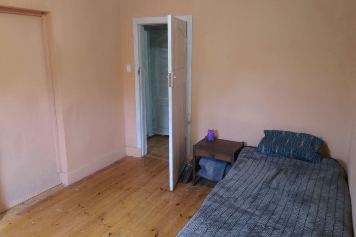 A bedroom featuring original timber flooring and a built-in cupboard, requiring cosmetic updates to improve the overall aesthetic and condition.