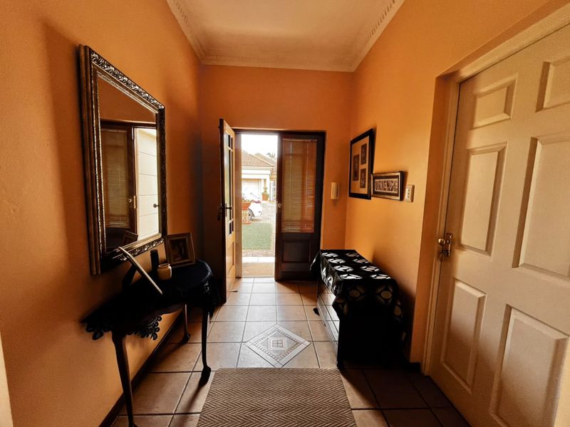 A welcoming entrance hall featuring tiled flooring and decorative ceiling cornicing, providing direct access to the home's interior.