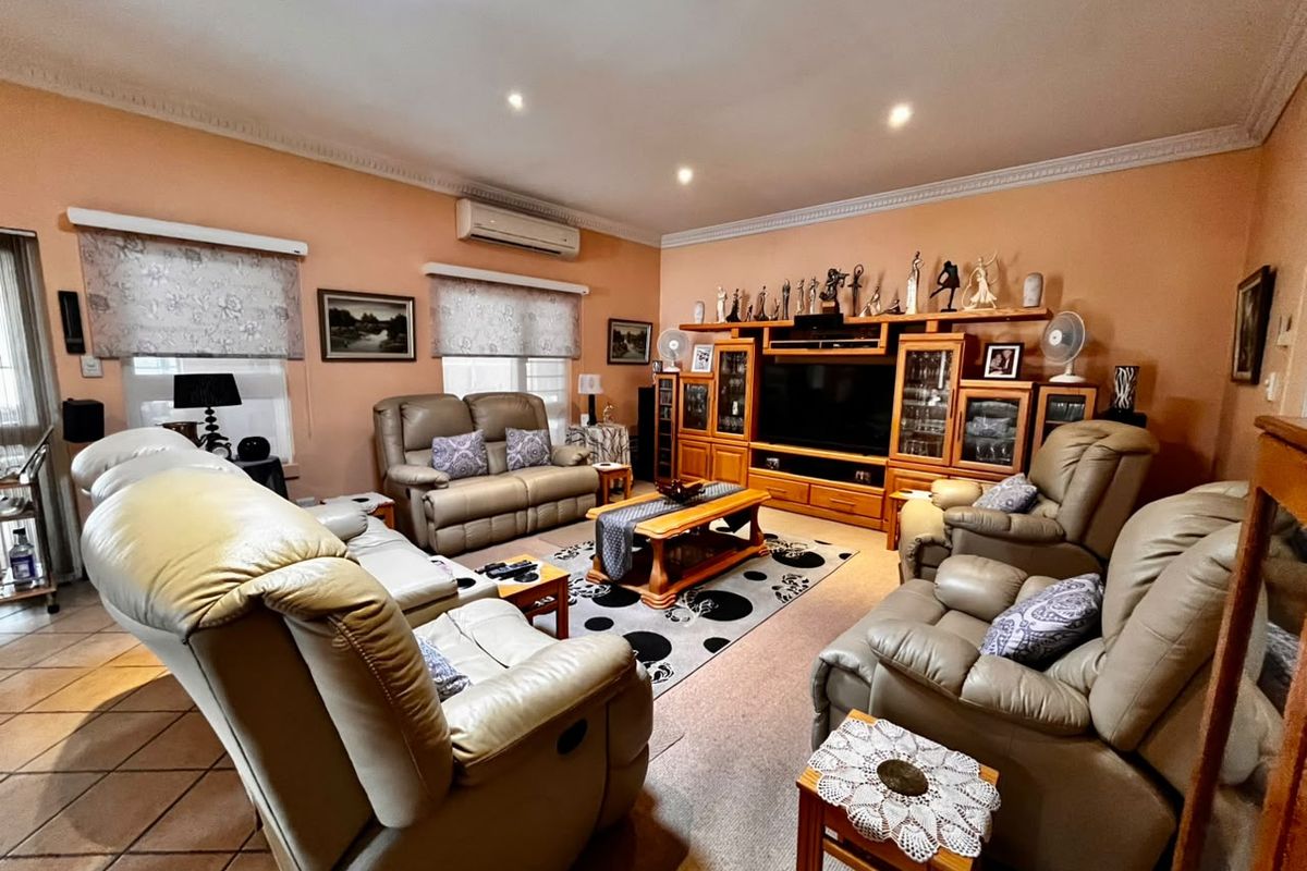 Spacious living room featuring a split-system air conditioner, crown molding, recessed lighting, and a combination of tiled and carpeted flooring.