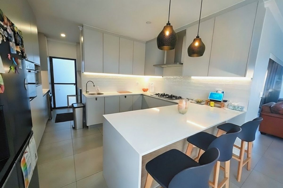 Modern kitchen featuring sleek cabinetry, stone countertops, integrated gas cooktop, and a breakfast bar with contemporary pendant lighting.