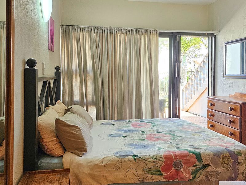 A bedroom featuring a sliding glass door that provides direct access to an outdoor patio area.