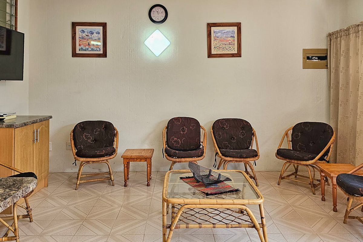 A living room area featuring tiled flooring and built-in cabinetry, providing a functional space for relaxation.
