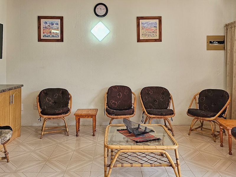 A living room area featuring tiled flooring and built-in cabinetry, providing a functional space for relaxation.