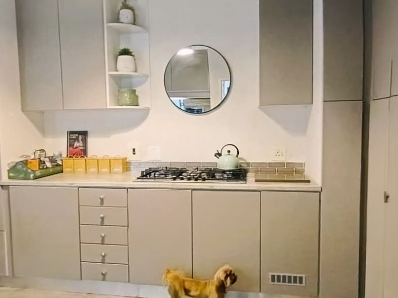 Modern kitchen featuring light grey cabinetry, a built-in oven, gas hob, and a stylish subway tile backsplash.