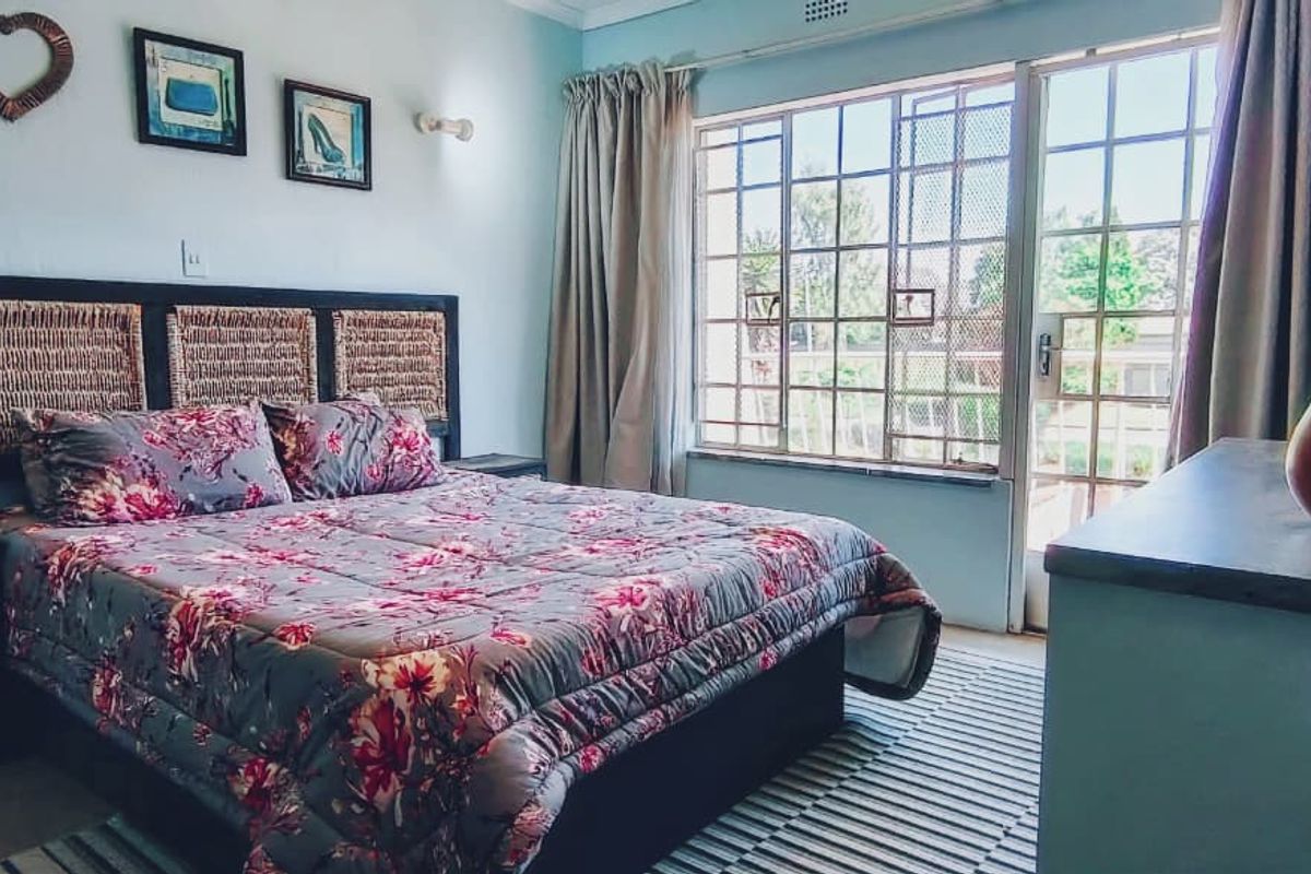 A bedroom featuring a large window and sliding door access, providing natural light and direct outdoor connectivity.