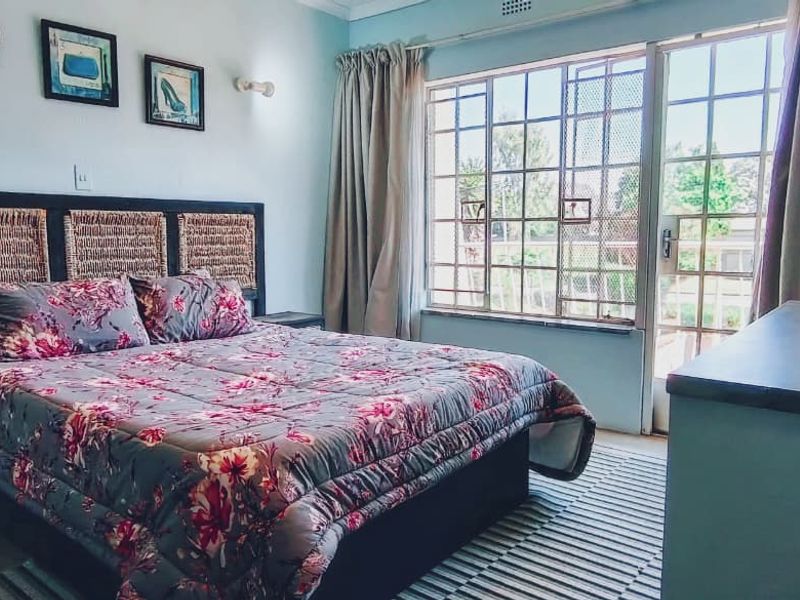 A bedroom featuring a large window and sliding door access, providing natural light and direct outdoor connectivity.