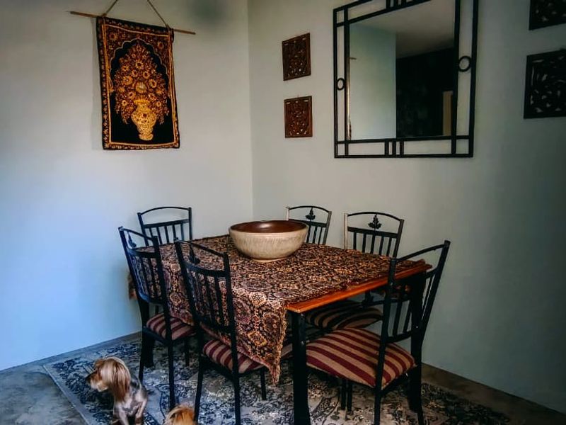 A dining room area featuring tiled flooring and an arched doorway leading to an adjacent space.