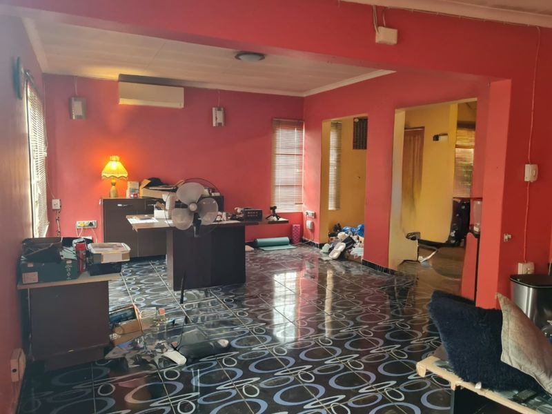 Spacious living area featuring patterned tiled flooring, split-system air conditioning, and multiple access points to adjacent rooms.