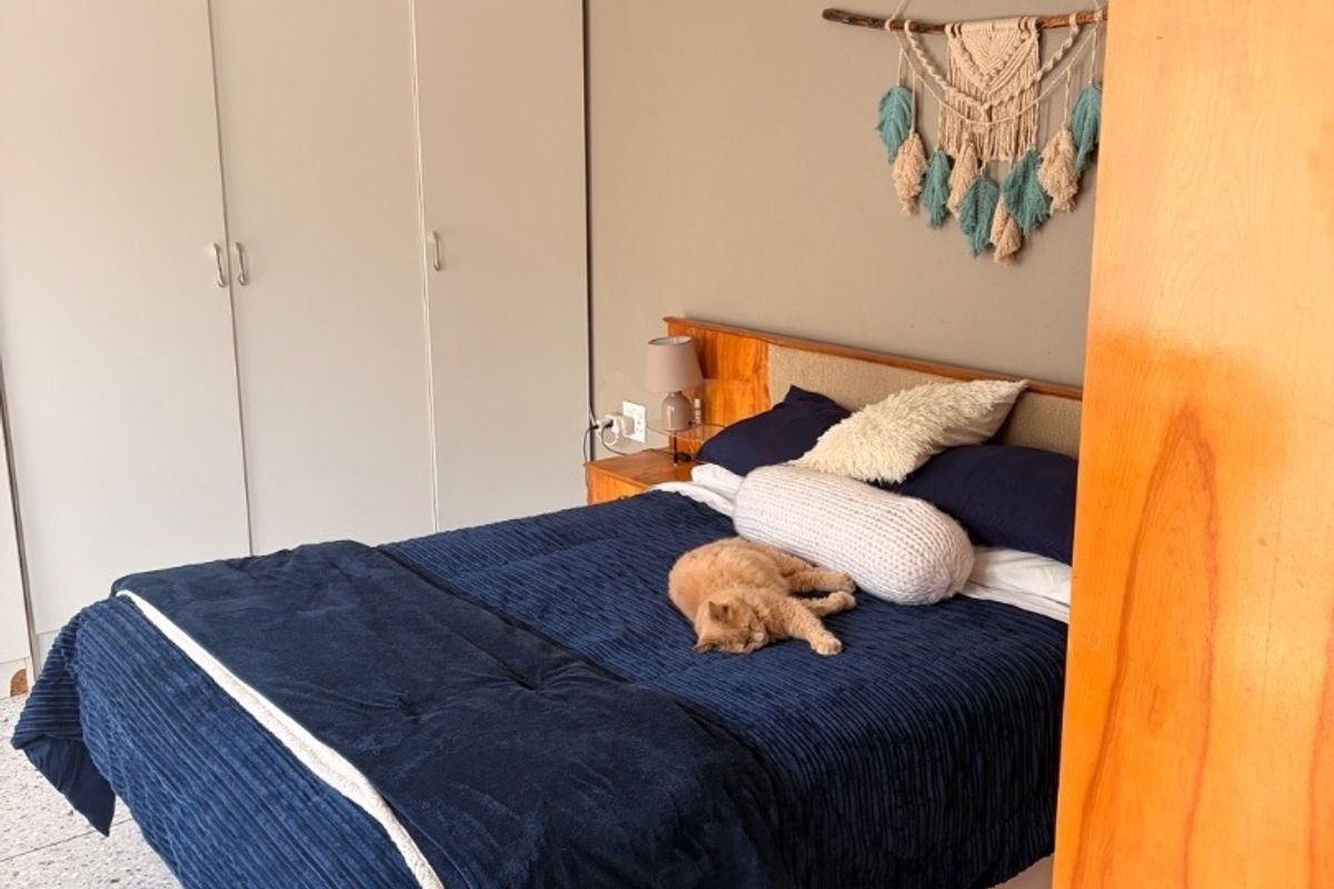 A bedroom featuring built-in wardrobes and terrazzo flooring, offering a functional space with neutral wall tones.
