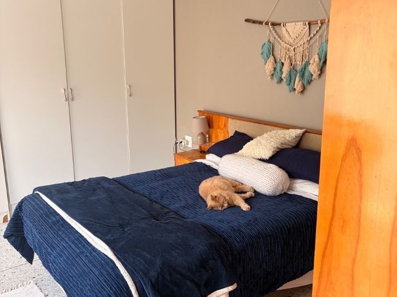 A bedroom featuring built-in wardrobes and terrazzo flooring, offering a functional space with neutral wall tones.