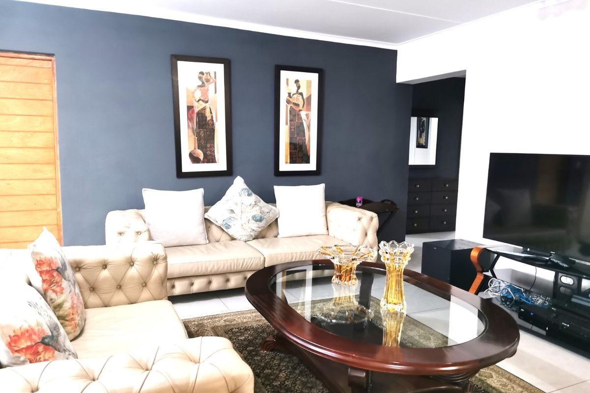 A comfortable living room featuring tiled flooring and a dark blue accent wall, creating a cozy and inviting atmosphere.