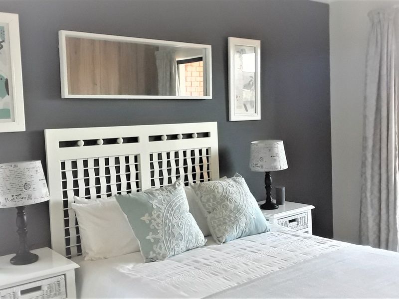 A well-maintained bedroom featuring a dark accent wall and a sliding glass door providing access to an outdoor area.