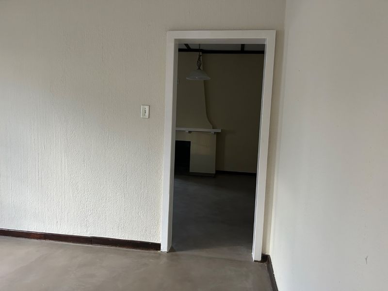 An empty living area featuring a fireplace and textured walls, offering a blank canvas for renovation and interior design updates.