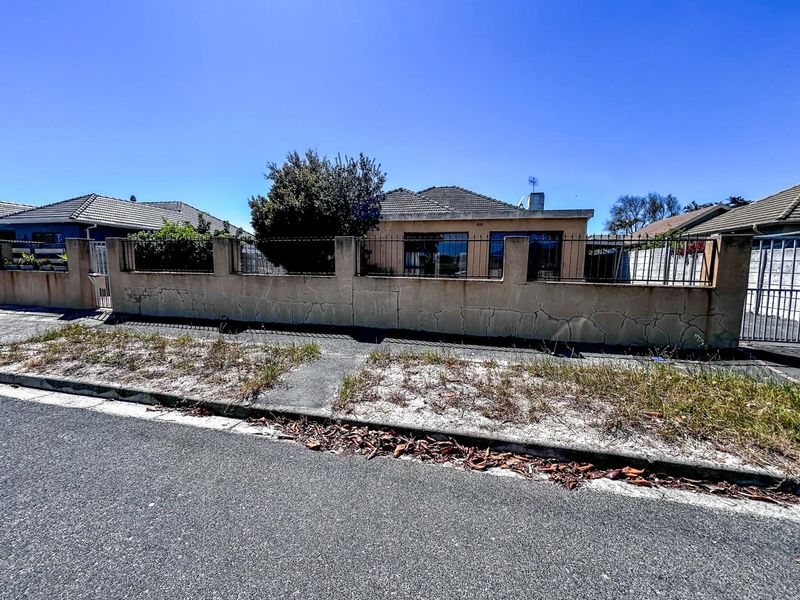 Front view of a residential property featuring a tiled roof and a perimeter wall with visible structural cracking requiring maintenance.