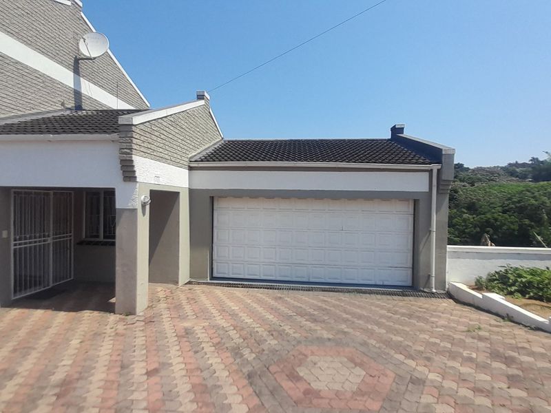 Front exterior view of the property featuring a paved driveway, a single garage with a white door, and a covered entrance area.