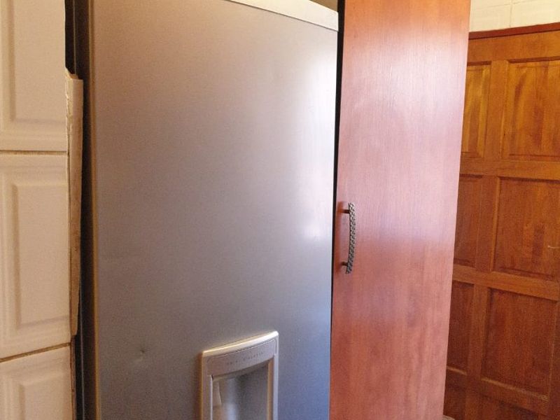 A close-up view of a kitchen area featuring built-in cabinetry, tiled wall finishes, and a wooden door.
