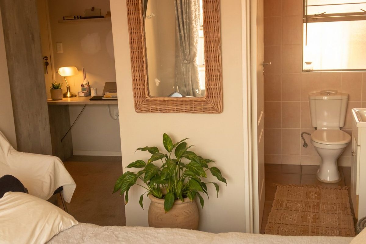 Bedroom featuring an integrated study nook and an adjacent en-suite bathroom with tiled finishes.