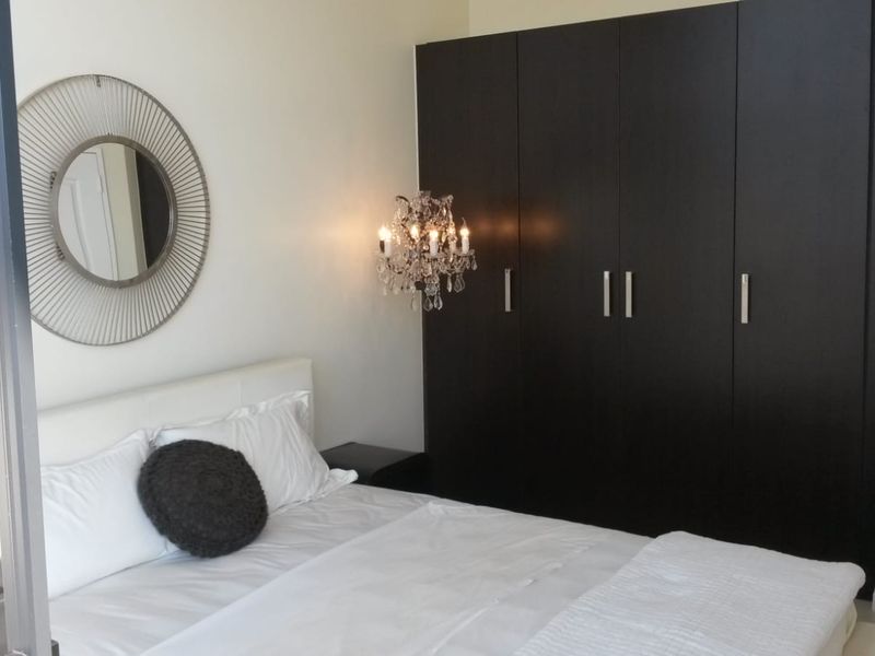 A well-maintained bedroom featuring dark wood built-in cupboards and neutral finishes, offering a clean and functional living space.