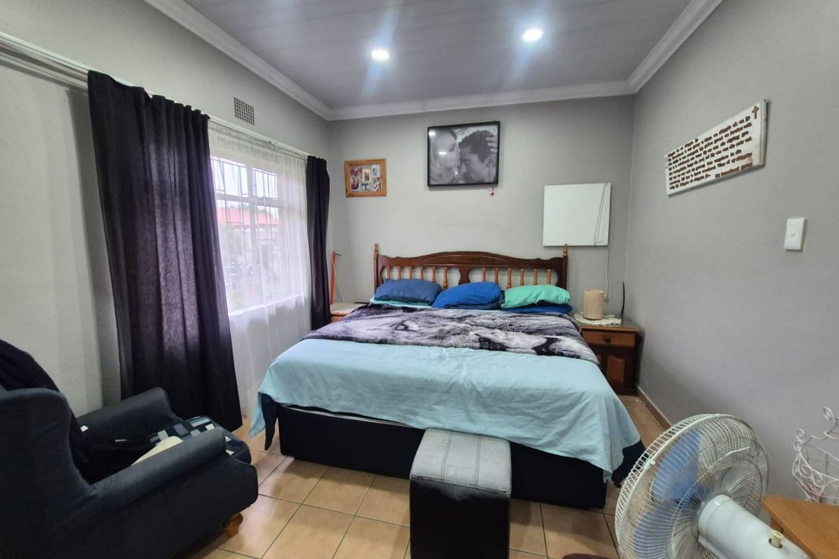 A functional bedroom featuring tiled flooring, recessed downlighting, and a coved ceiling, providing a comfortable and well-lit sleeping space.